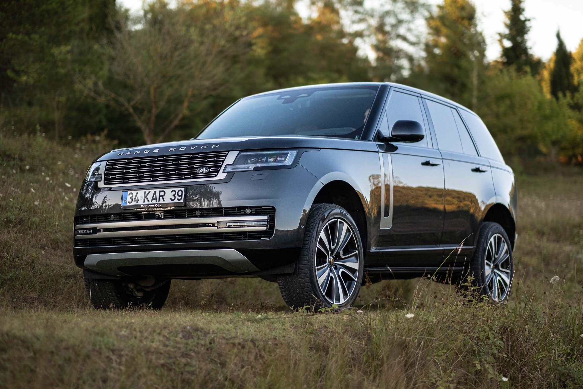 Range Rover lüks SUV'un doğa arka planında ön açı fotoğrafı